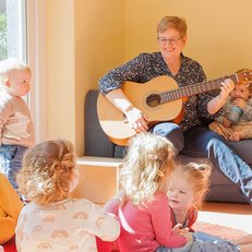 Erzieherin musiziert mit U3-Kindern