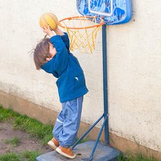 Kitakind wirft Basketball in Korb